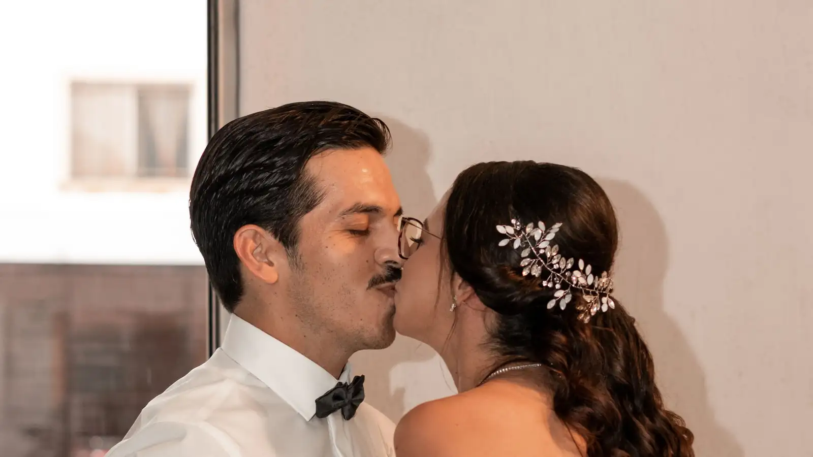 Los novios se besan en interiores; ella lleva flores en el cabello
